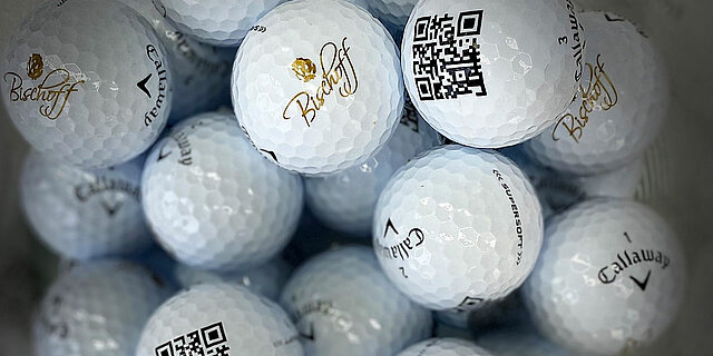 Schüssel mit Golfbällen, die das Bischoff-Logo und einen QR-Code aufgedruckt haben